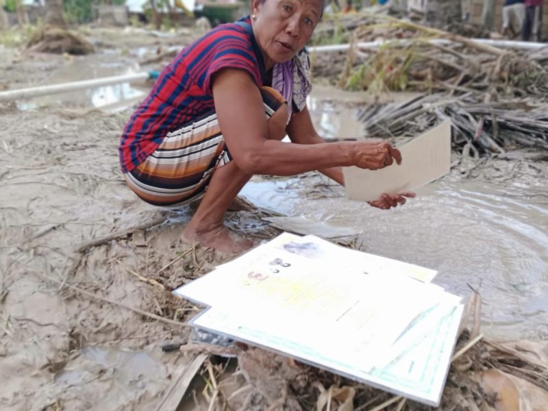 Tampak salah satu warga desa Pukdale, Kabupaten Kupang membersihkan dokumen-dokumen penting pasca bencana banjir yang menimpa daerah tersebut. (Foto: Adi Kebkole, STC)