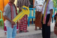 Ketua Yayasan Pelita Kehidupan Masyarakat (YPKM), Sandy Mathias Rupidara (kiri) menyerahkan kunci rumah secara simbolis kepada warga desa Fatukopa yang mendapat bantuan rumah layak huni dari YPKM.  